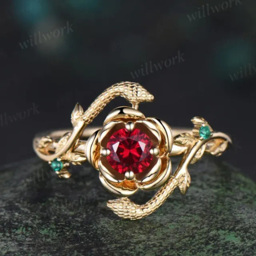 Gold bracelet with snake motifs and a central red gemstone