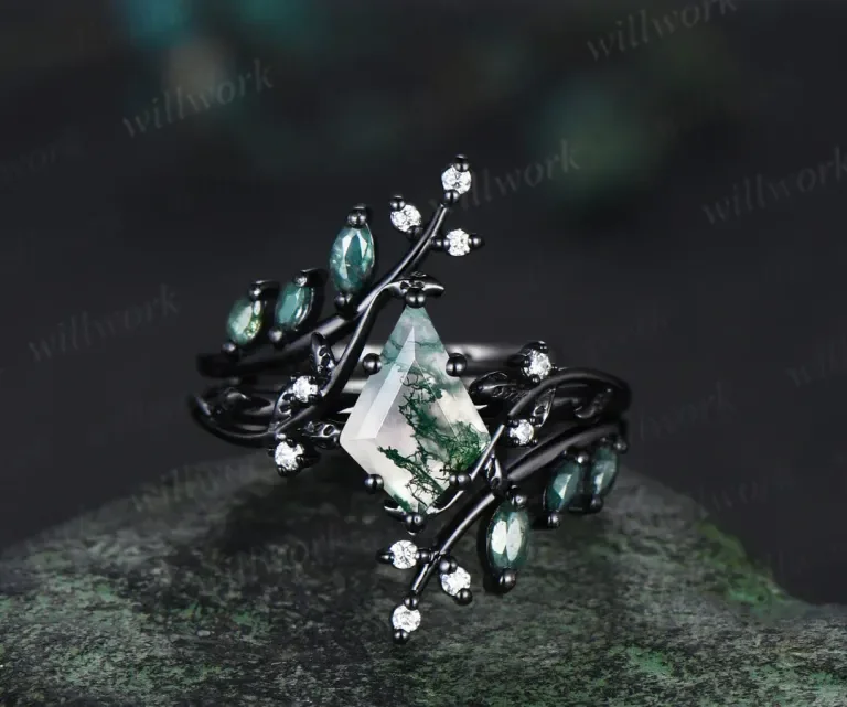 Close-up of a black metal bracelet with green gemstones and clear crystals, featuring a central triangular gemstone with a tree reflection.