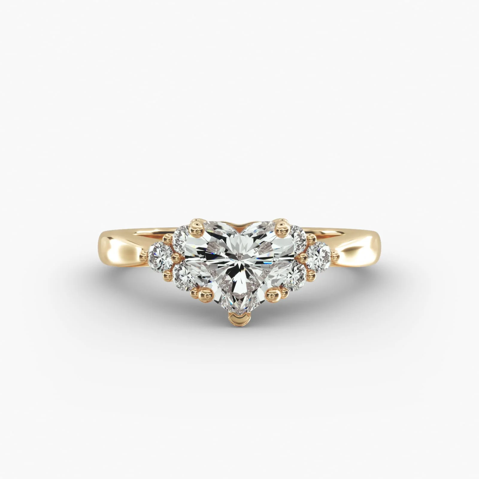 Gold ring with a heart-shaped central diamond surrounded by smaller diamonds on a white background.