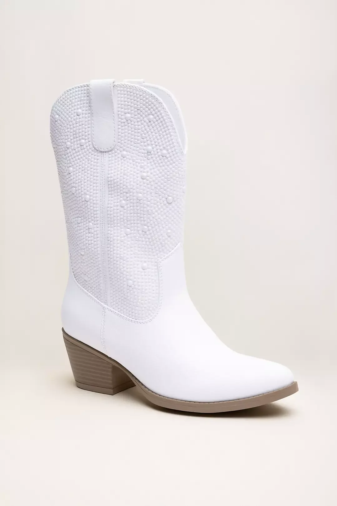 White cowboy boot with a textured, dotted pattern on the shaft and a light brown, stacked heel, set against a plain background.
