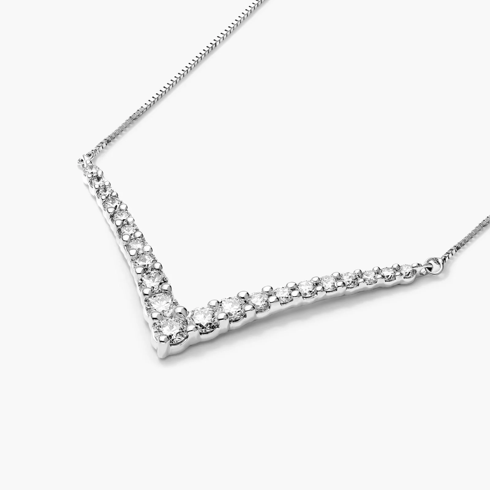 Silver necklace with a V-shaped arrangement of clear gemstones on a white background.