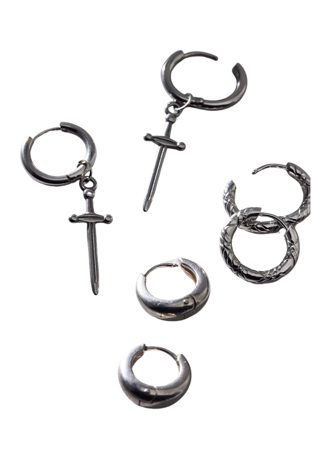 Close-up of multiple silver hoop earrings, with different designs, arranged on a black background.