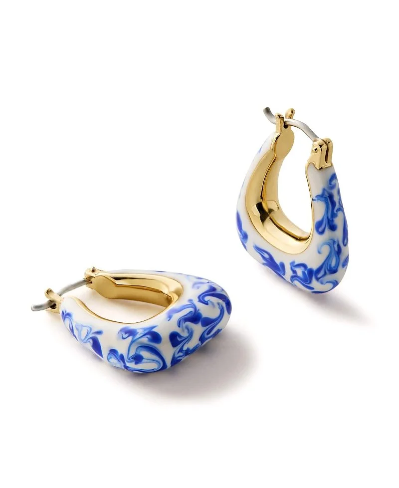 Gold and blue porcelain hoop earrings with a floral design, on a white background.