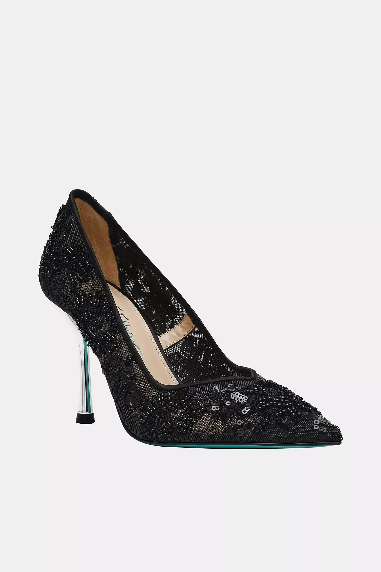 A black high-heeled shoe decorated with black beads and sequins, with a pointed toe and transparent heel, set against a plain light gray background.