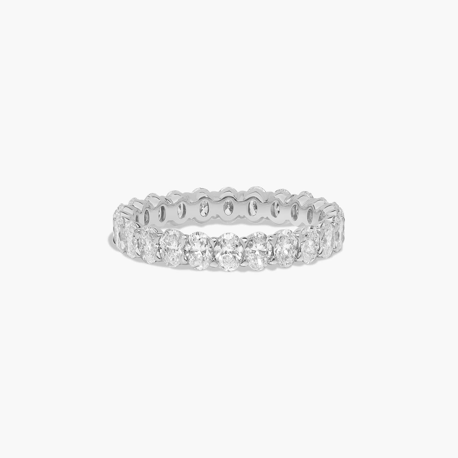 Silver eternity ring with multiple round-cut diamonds set around the band.