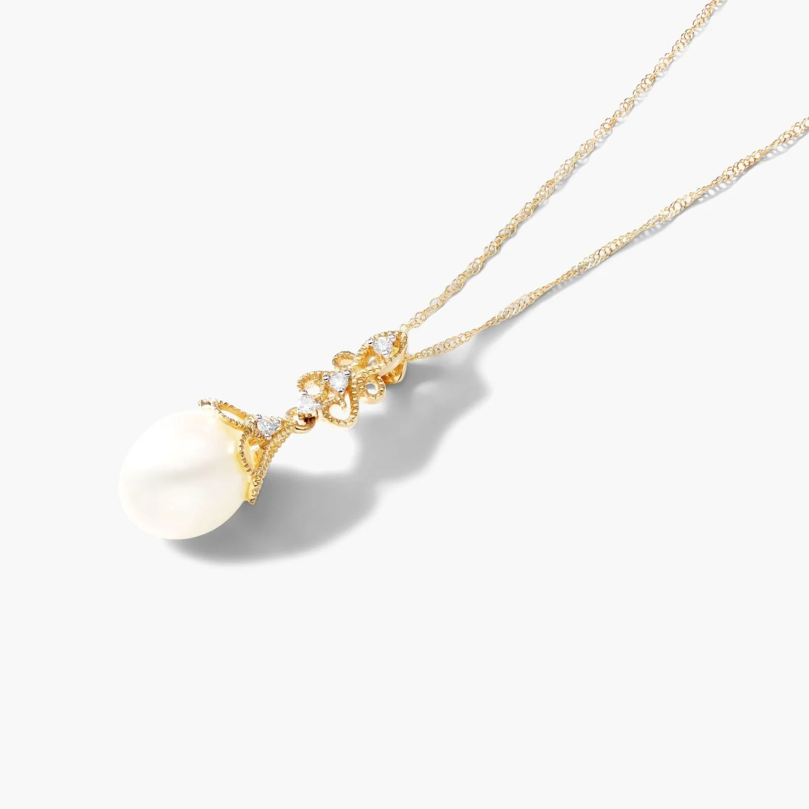 Gold necklace with a large pearl pendant and small diamonds against a white background.