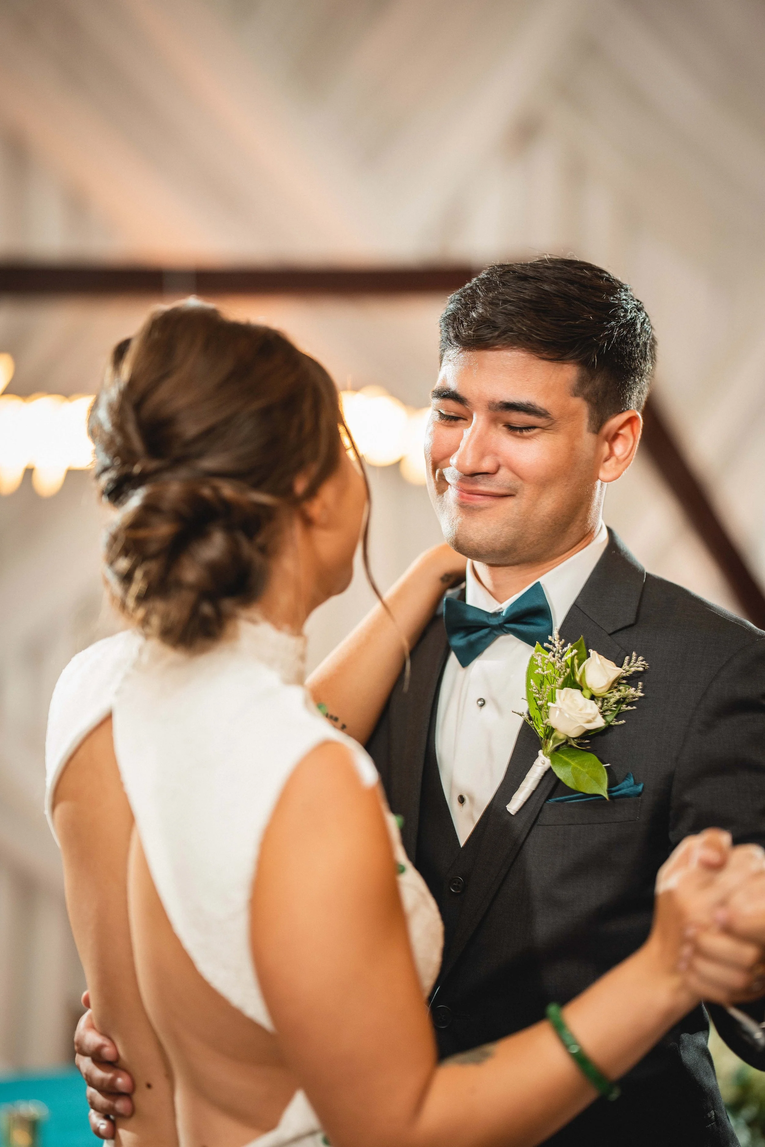 A bride and groom share a dance at their wedding reception, smiling lovingly at each other, San Clemente Shores Wedgewood
