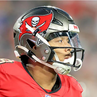 Close-up of a football player wearing a Tampa Bay Buccaneers helmet with a pirate flag skull logo and a red jersey.
