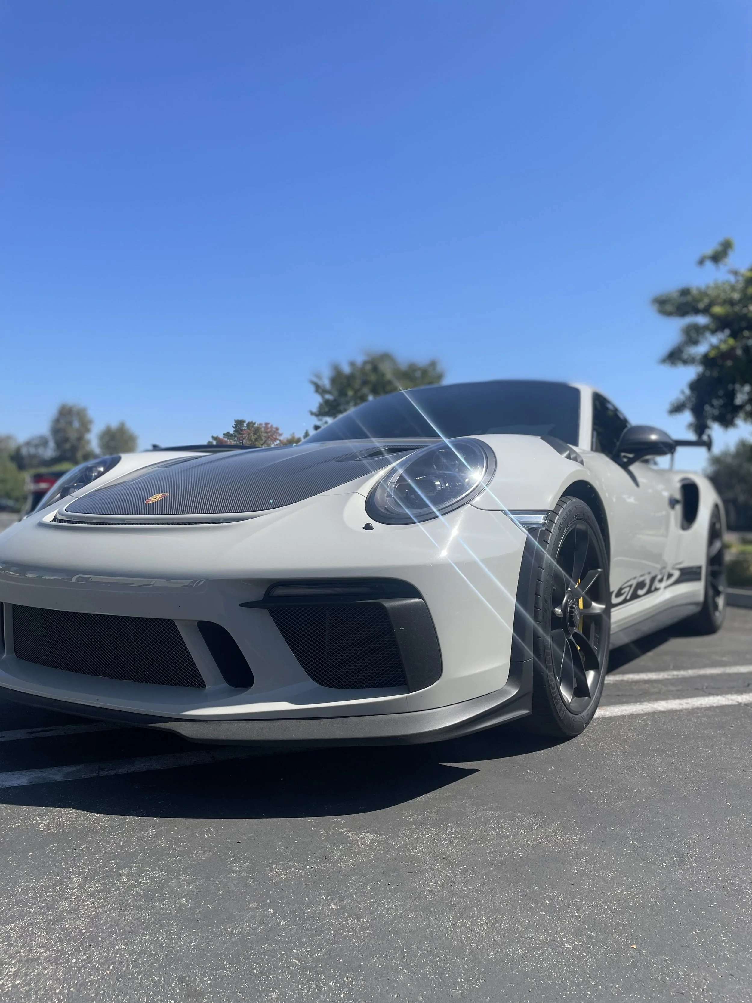 White Porsche gt3rs wrapped in gloss clear paint protection film ( PPF ) with a carbon fiber hood