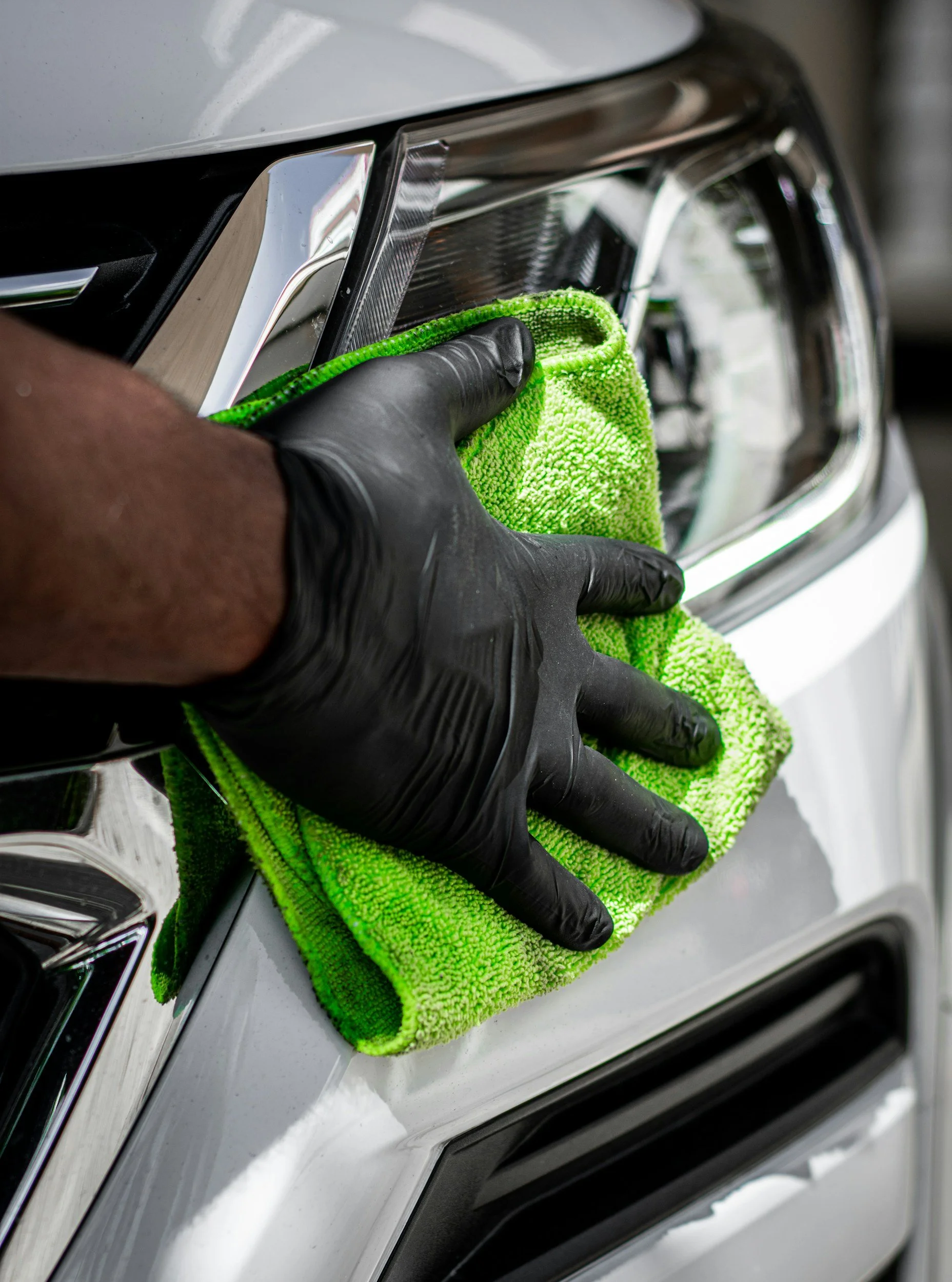 Kalamazoo mobile detailing technician hand-cleaning steering wheel with microfiber cloth for a streak-free, sanitized finish