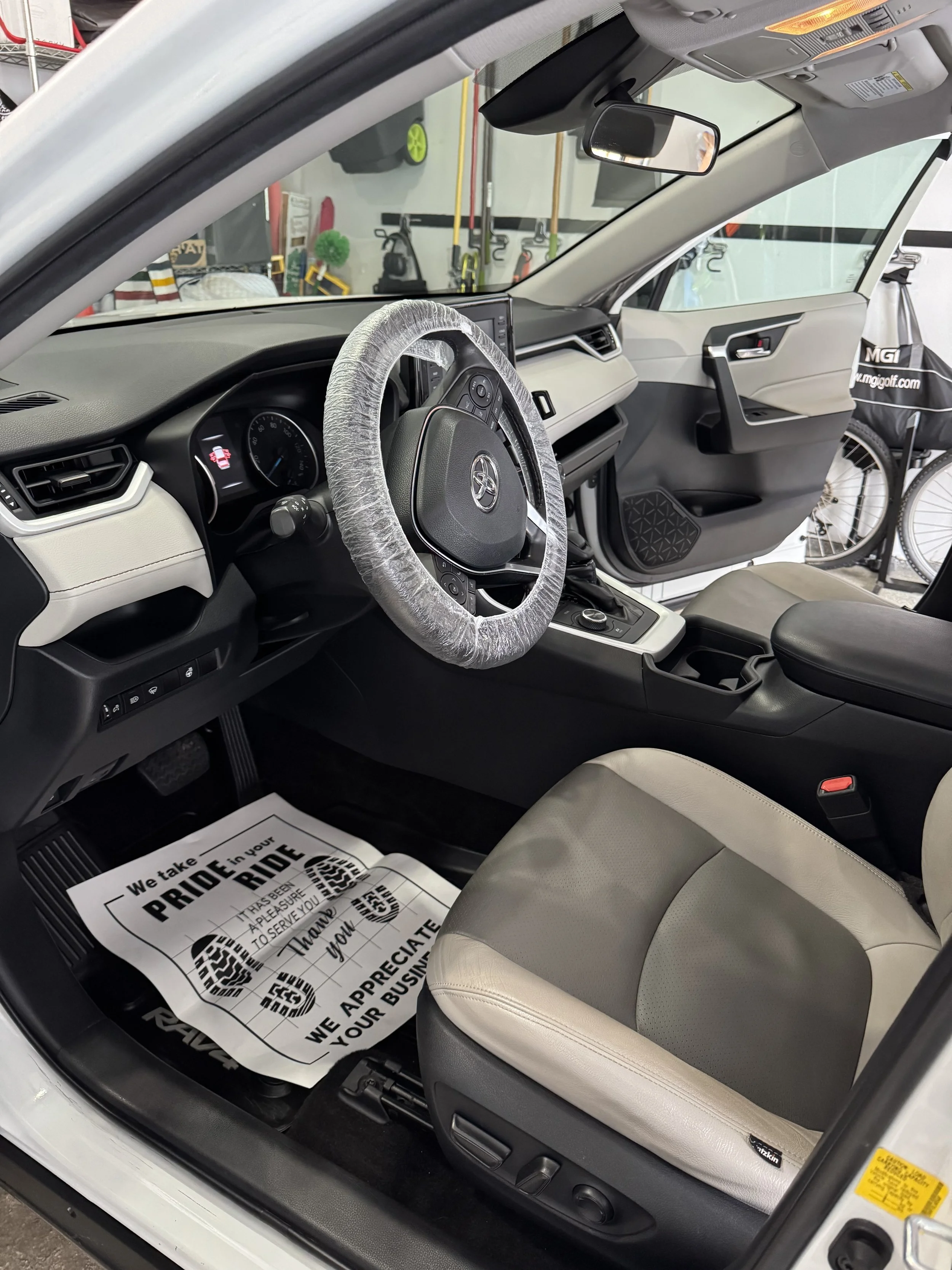 Mobile car detailing technician deep cleaning leather seats and interior of SUV in Kalamazoo driveway — professional auto detailing service