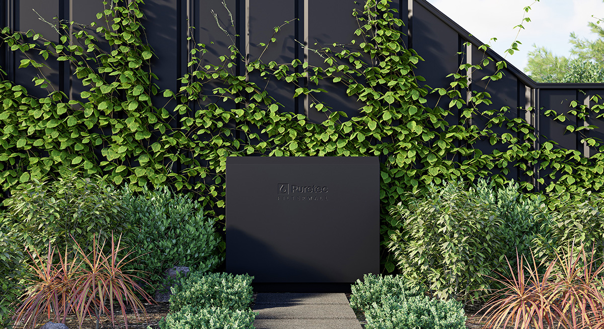 Black Puretec filter wall with green climbing plants and various shrubs in front