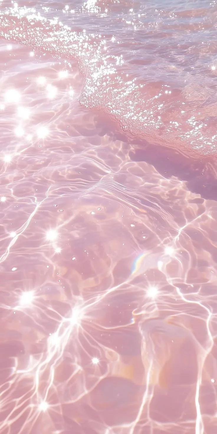 Pink-tinted water with sunlight reflecting off the surface, creating sparkles and shimmering patterns.