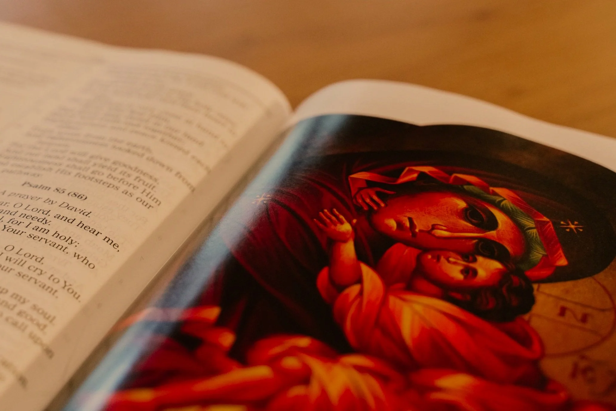 Open Bible showing a colorful religious artwork of Mary holding baby Jesus, with a focus on the text of Psalm 55:16-17.