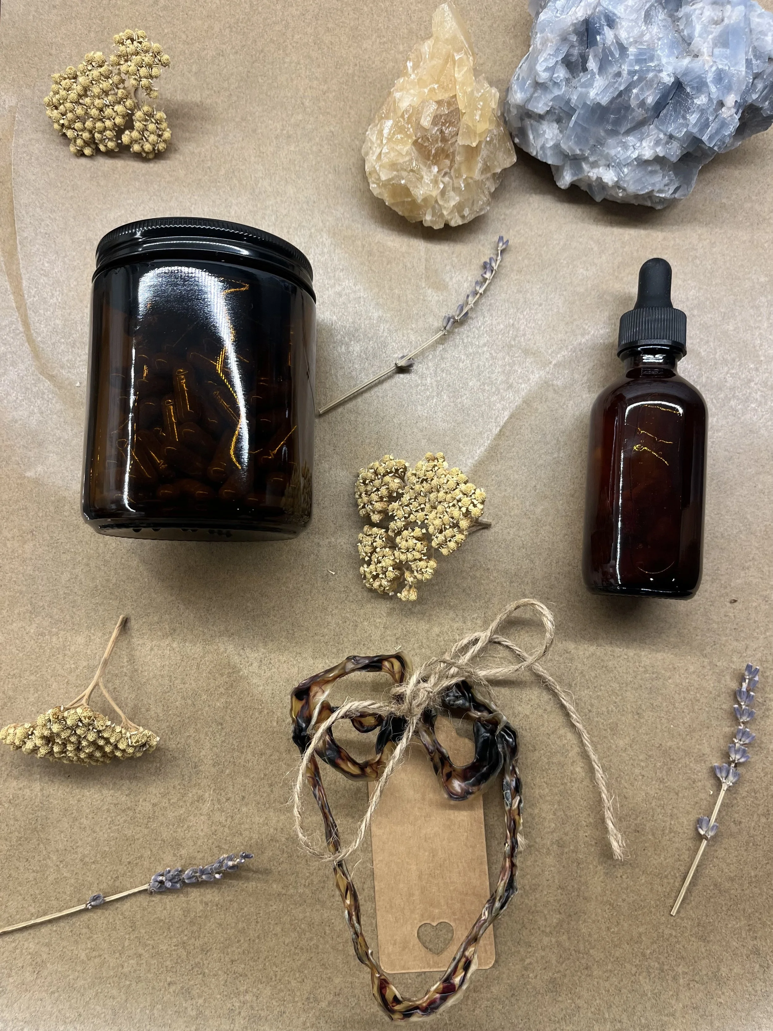 Modern building with wood and metal exterior, large glass window, set against mountainous landscape and grassy foreground.