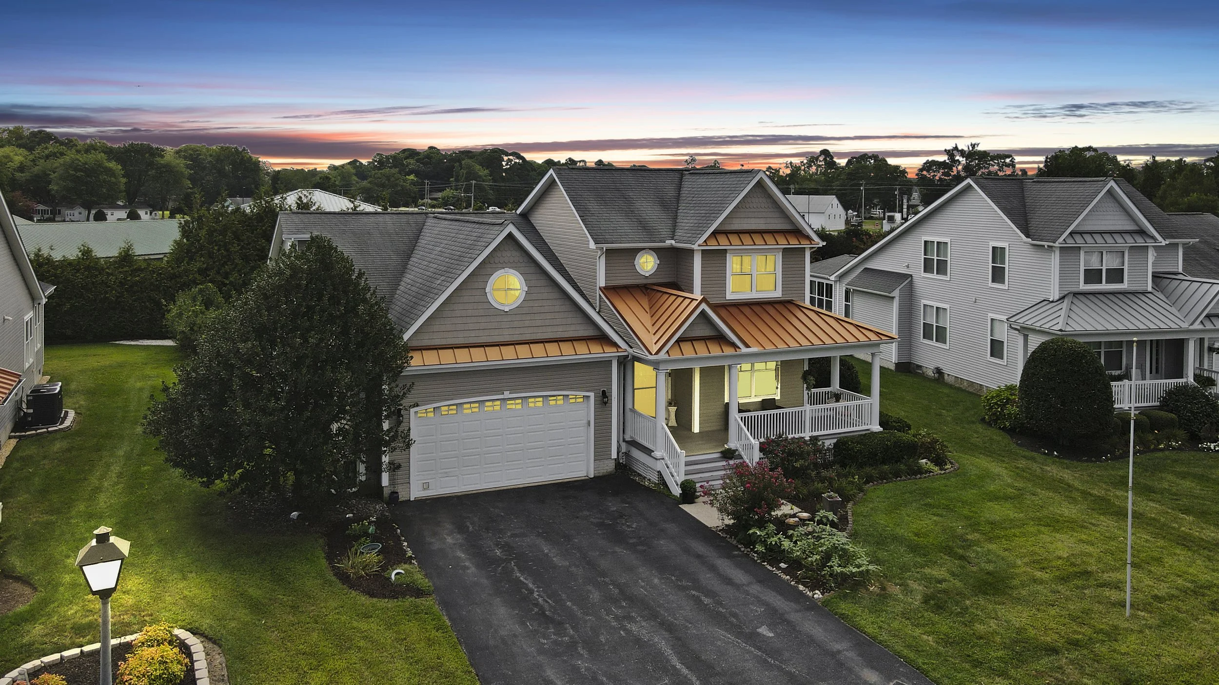 Living room with a beige sectional sofa, large window, TV mounted on the wall, plants, and a fireplace.