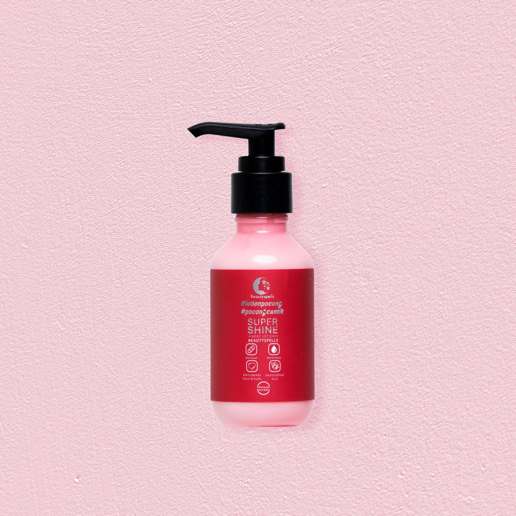 A pink bottle of body lotion with a black pump dispenser and red label, placed on a pink textured background.