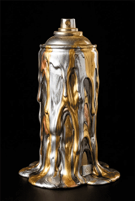 A spray paint can covered in dripping metallic silver, gold, and bronze paint against a black background.