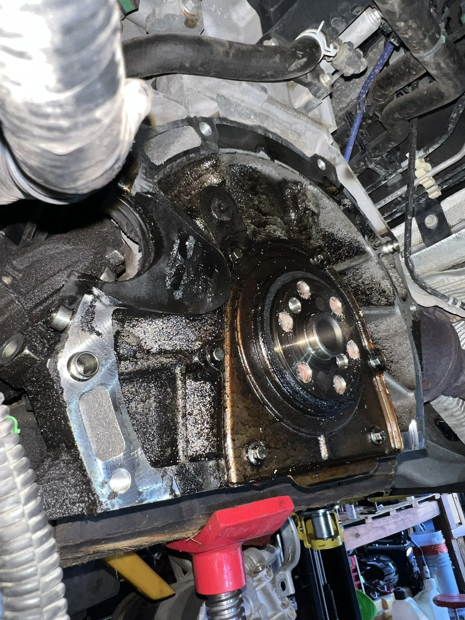 Close-up of a car engine with the timing cover removed, revealing the timing chain and camshaft.