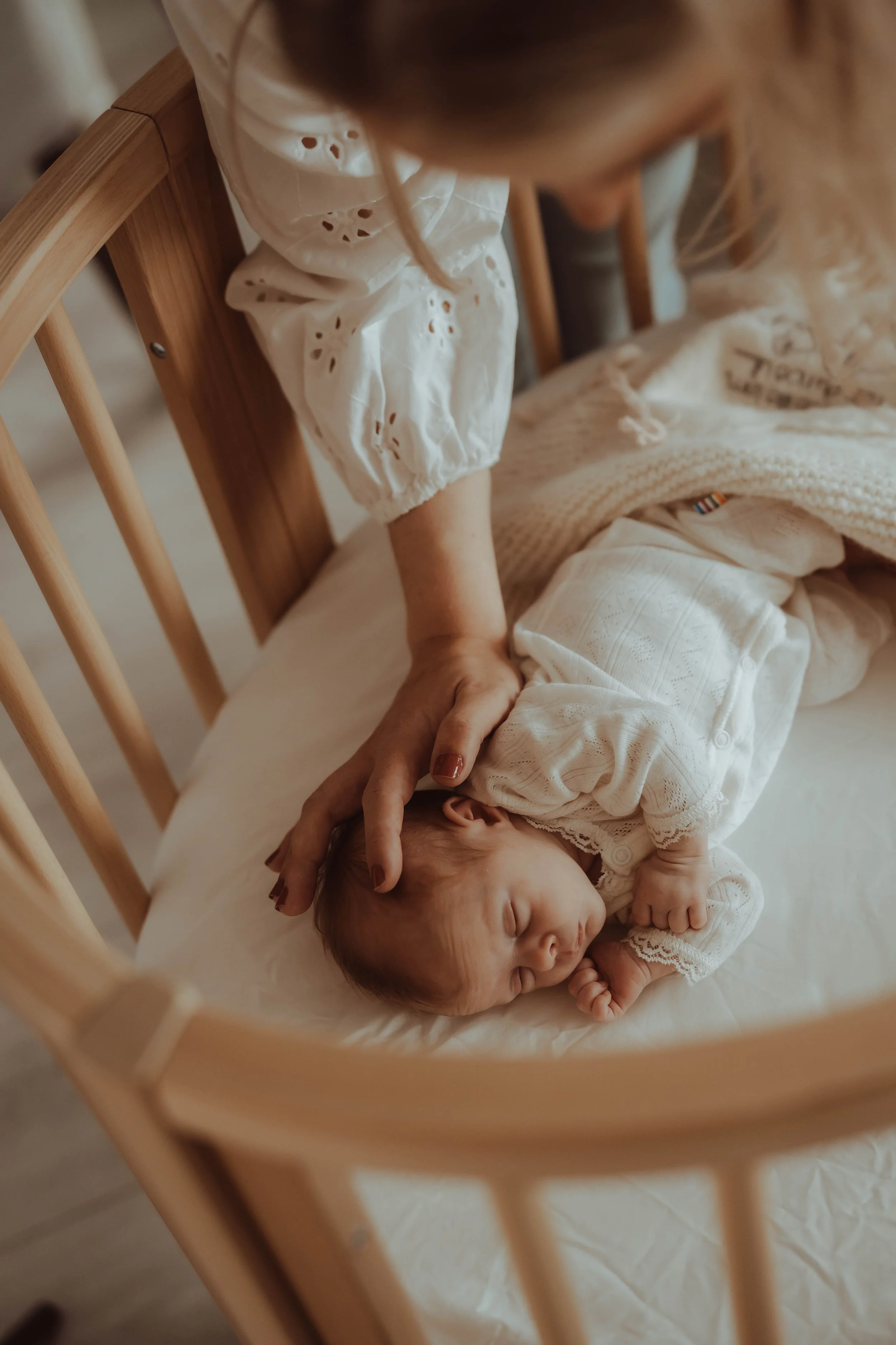 Nyfødtbilder av baby i seng tatt av fotograf i Lier