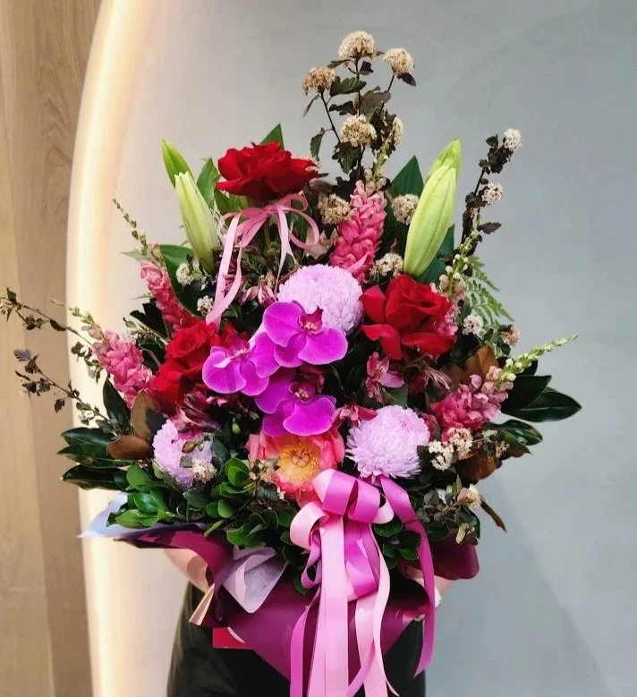 Large event arrangement in pinks and reds with roses orchids peonies and lillies