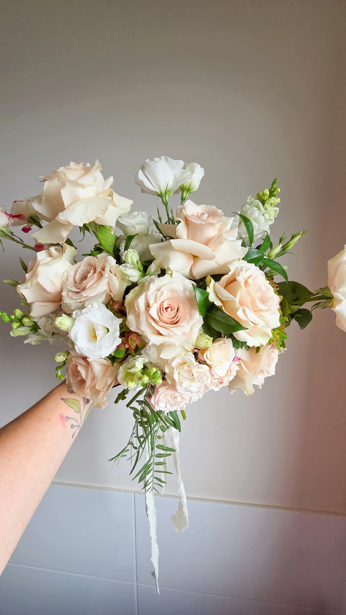 pastel toned wedding bouquet featuring quicksand roses, hydrangeas and lisianthus