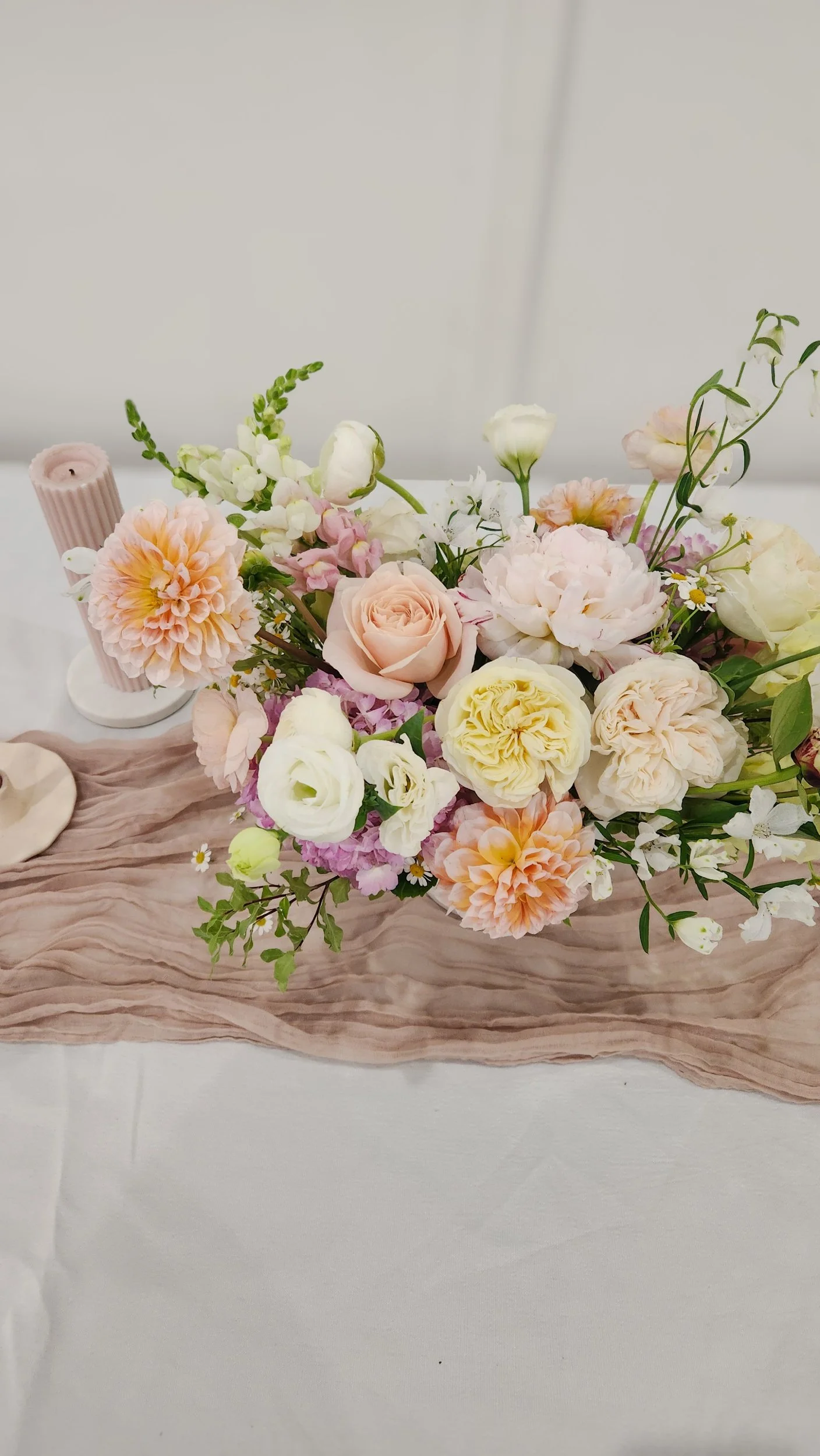 abundant garden style centerpiece, with roses, peonies, hydrangeas, dahlias and seasonal textures