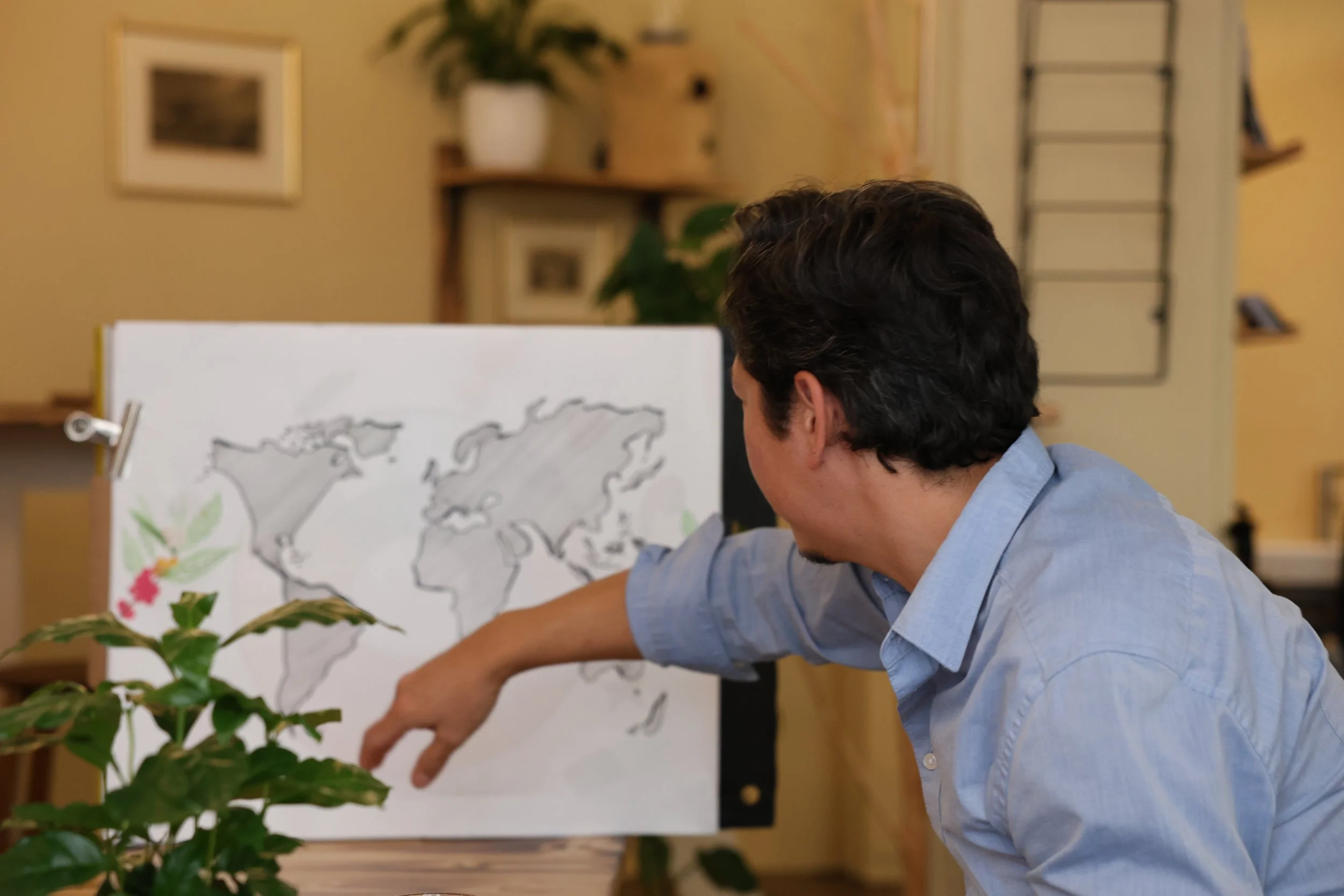 Two women tasting coffee from black cups on a wooden table in a cozy room.