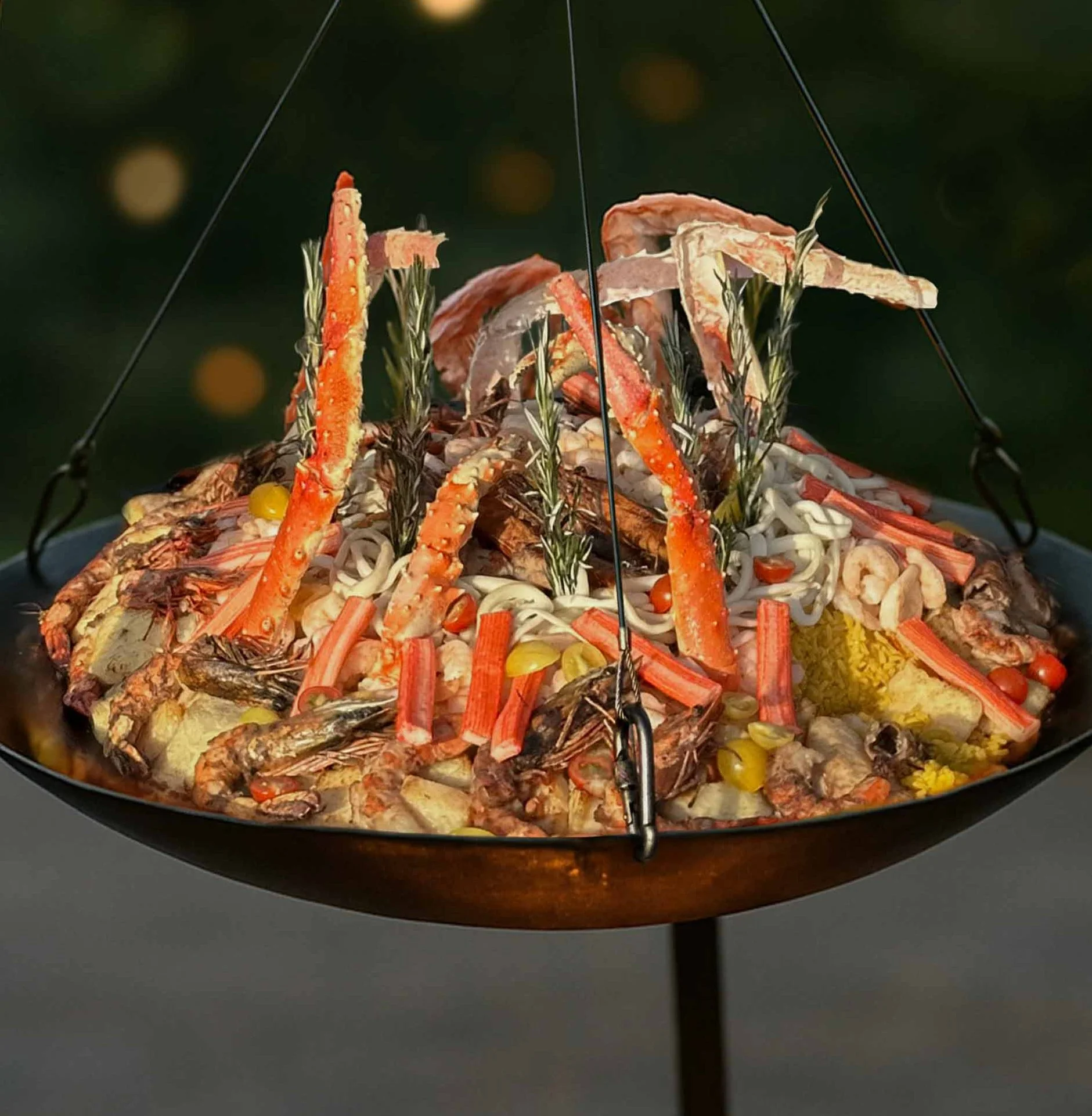 A large seafood display with crab legs, shrimp, fish, and crab, garnished with herbs and vegetables, on a hanging scale or serving platter.
