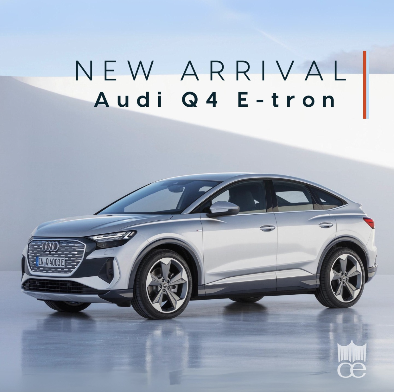 New silver Audi Q4 E-tron SUV on a reflective surface with a white and blue background, advertisement for the vehicle's arrival.