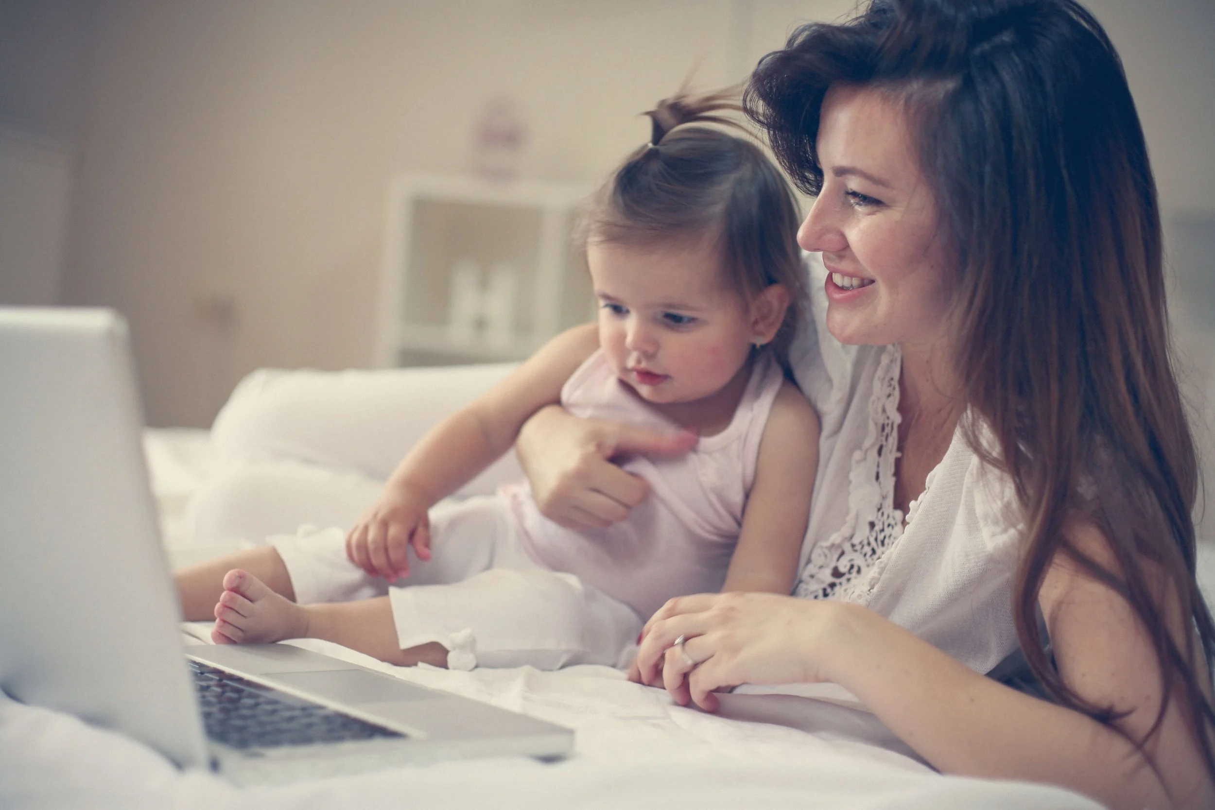 mom holding baby while doing online therapy session