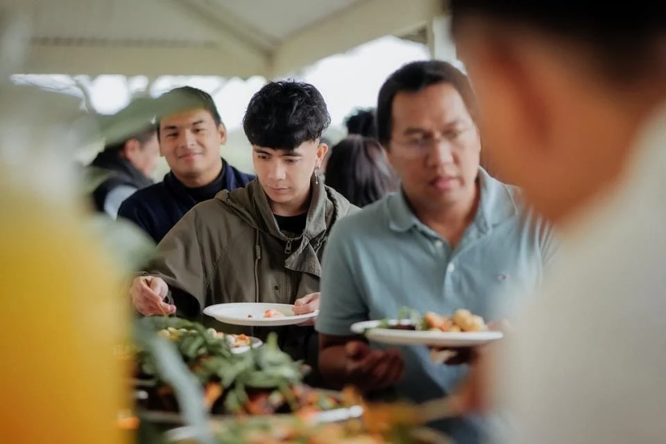 People serving themselves food at a buffet.