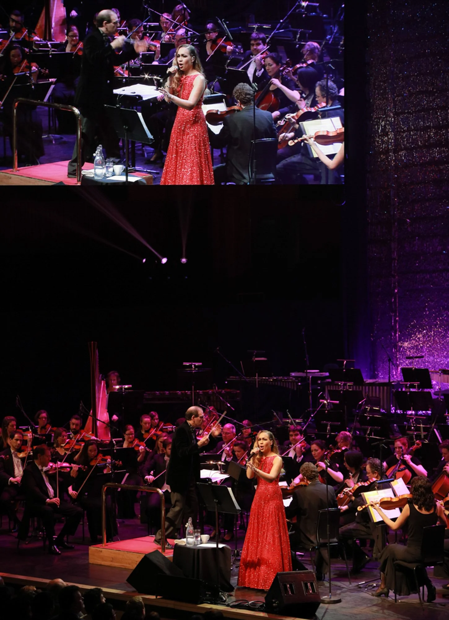 A woman singing on stage with an orchestra, conducted by a man, during a concert. The woman is wearing a red gown, and the orchestra includes strings, brass, and percussion instruments, with a harp visible in the background.