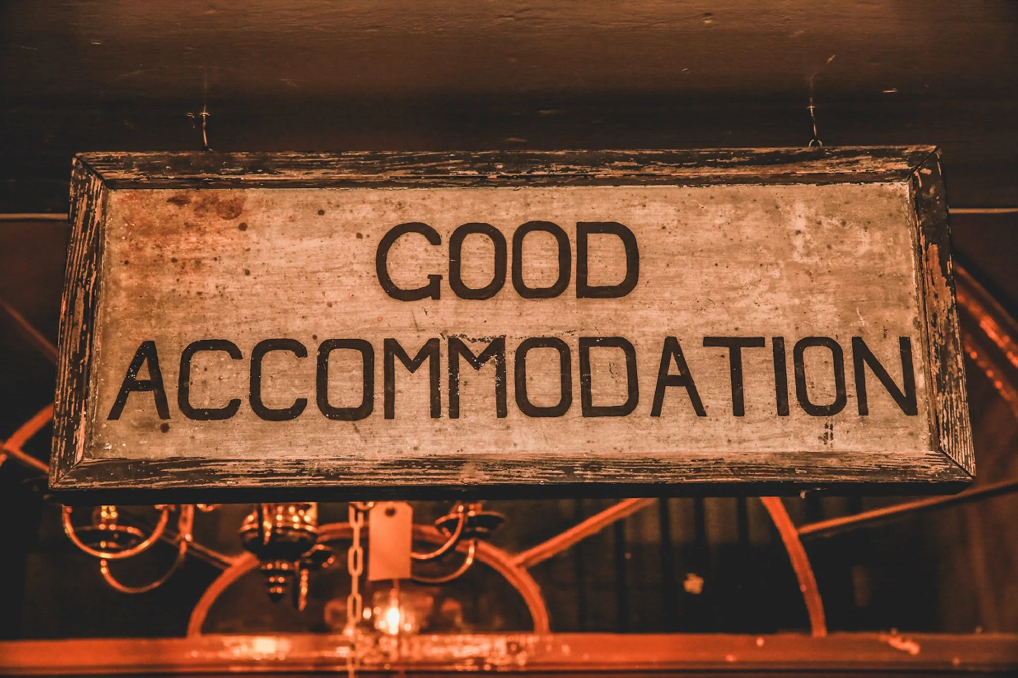 Wooden sign with the words 'Good Accommodation' in black letters