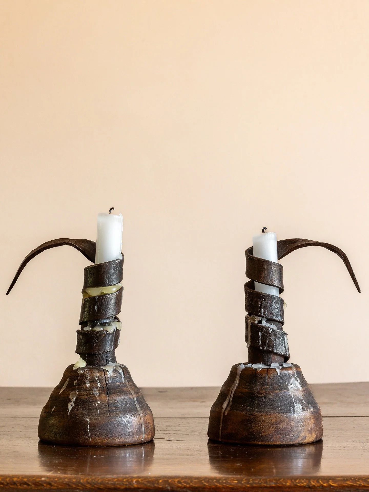 An atmospheric pair of 19th Century Irish candlesticks in forged iron on wooden bases