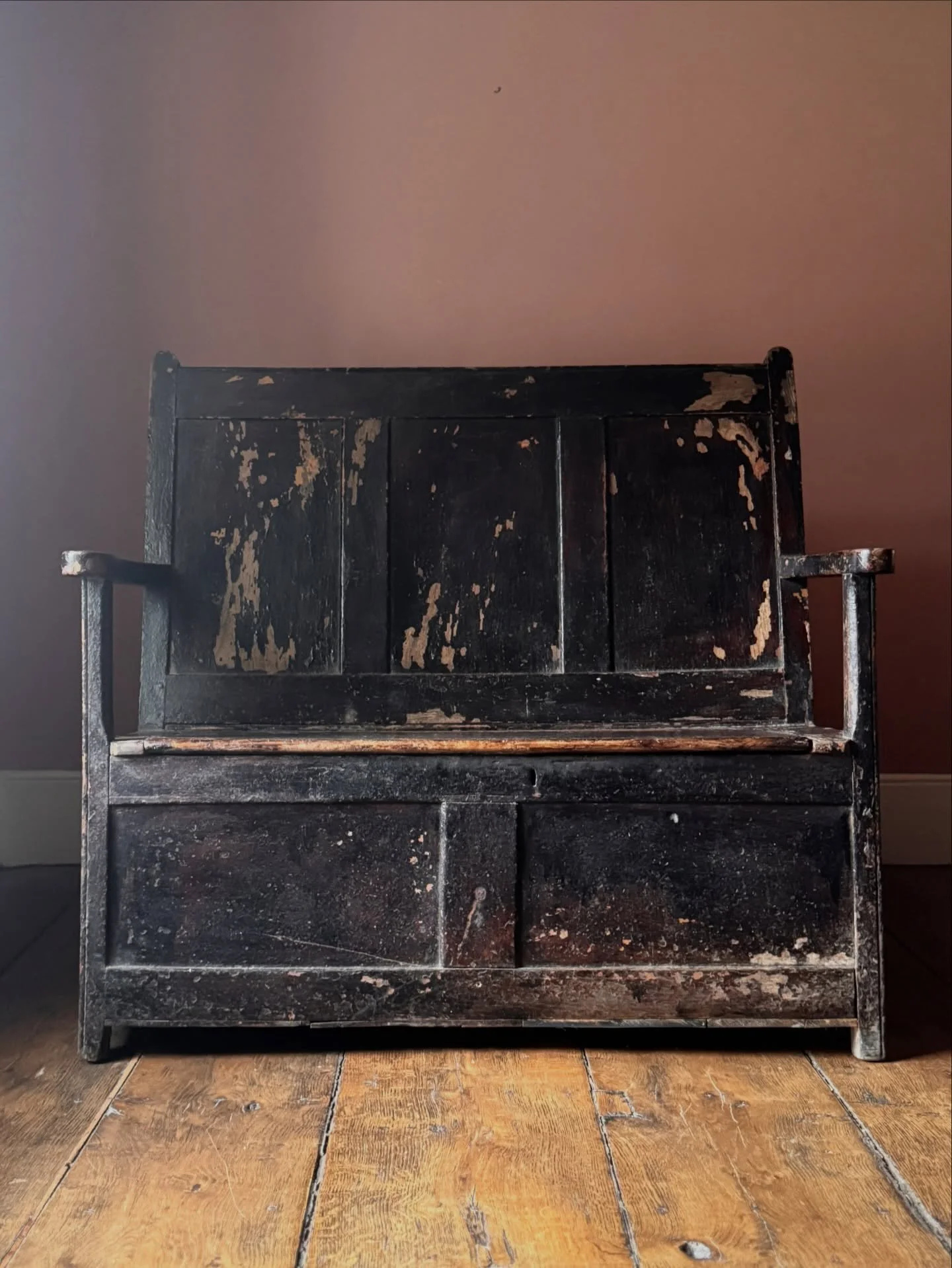 A wonderful barn fresh 19th Century Welsh settle from Cardiganshire. In pine with three panels and two lids on the seat for storage. It has a superb worn painted finish revealing at least three layers of historic colour. The overall effect is very at
