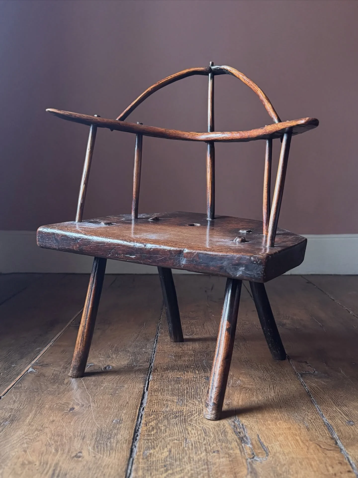 An exceptional early 18th Century primitive Welsh stick chair. Everything you could want from this kind of chair - fantastic colour, wonderful unique shape, and lots a character. It has a thick oak slab seat with ash arms, legs and spindles. It appea
