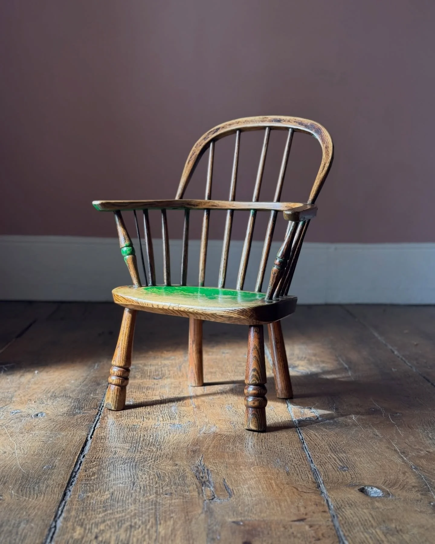A really joyful little 19th Century child&rsquo;s Windsor chair. Much loved with tons of character this chair has beautiful remnants of historic green paint, a replacement spindle in metal, and another spindle half missing, all of which add to its wo