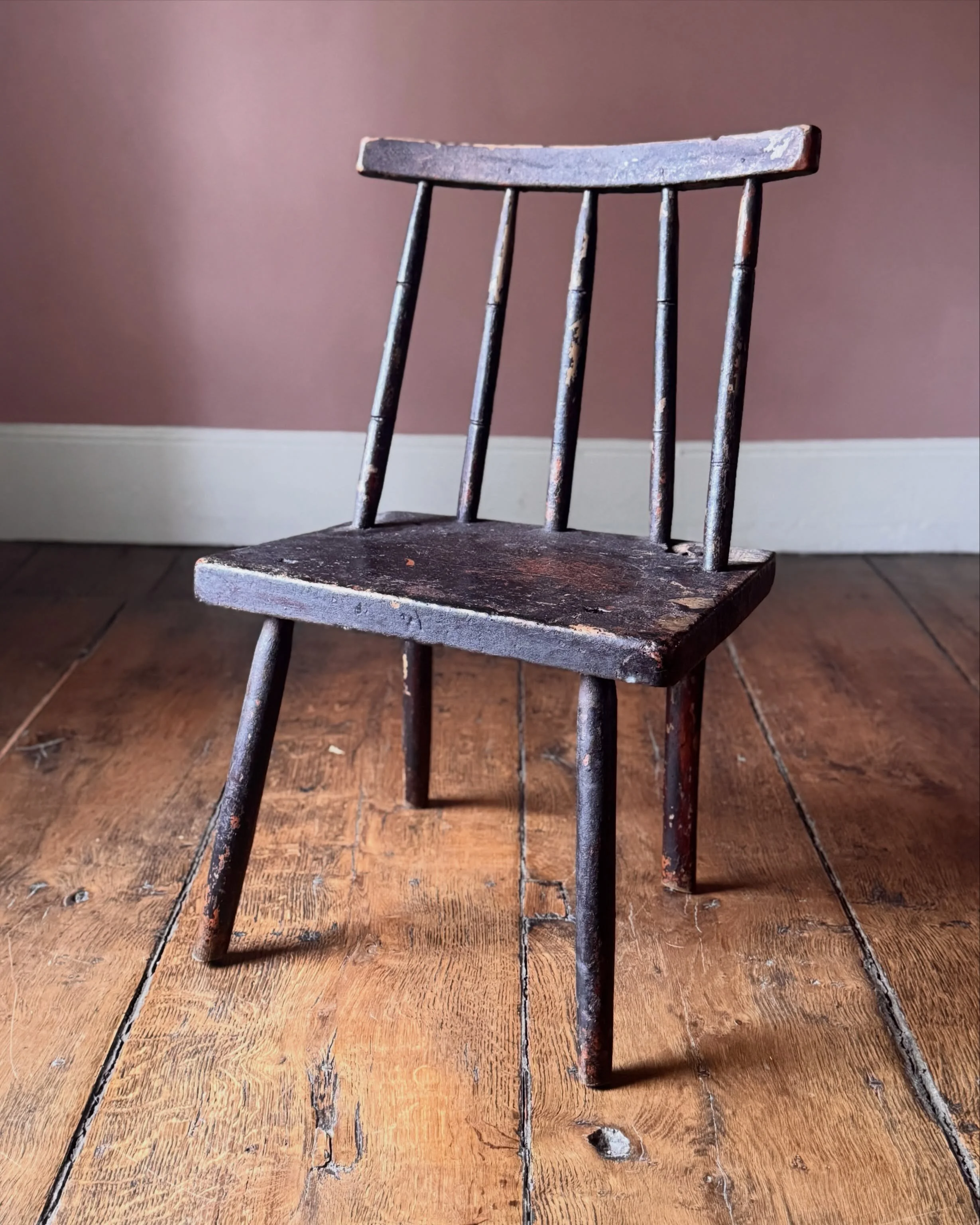 Full of character and with original dark paint, this vernacular 19th Century hedge chair from Cork has a curved crest rail, spindle back, and panelled seat raised on outswept legs. 

A really lovely piece of primitive Irish furniture. 

Height 76.5 c
