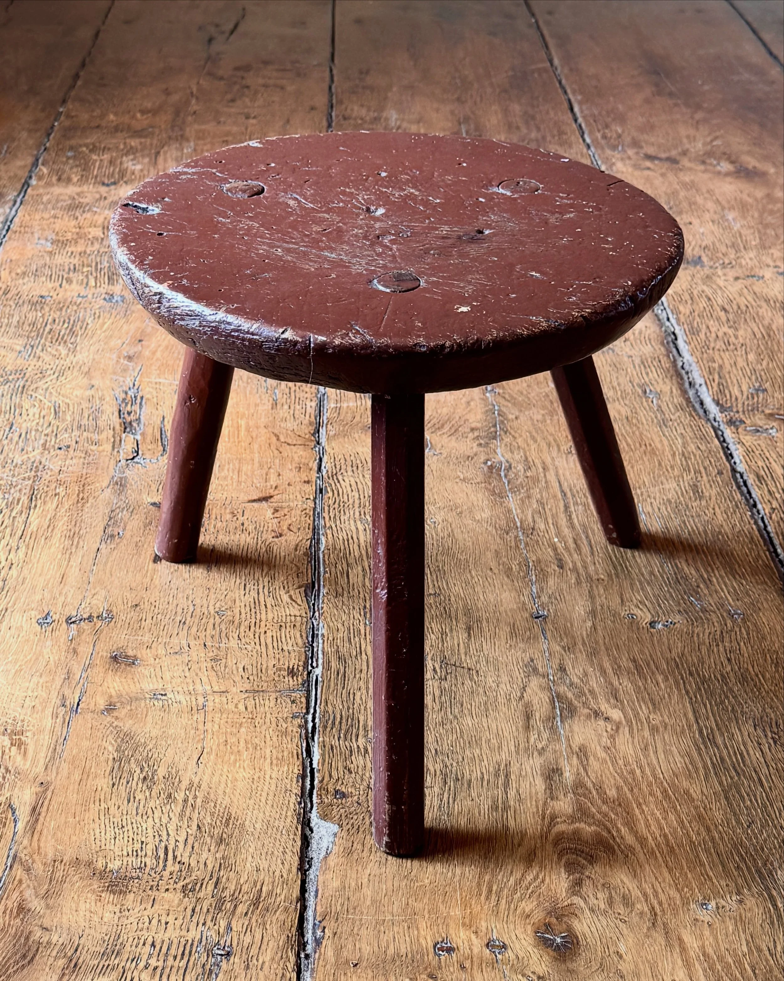 Large sturdy round 19th Century country stool in historic red paint. People often refer to these stools as milking stools but in reality they were and are versatile things with multiple uses. So don&rsquo;t be put off if you don&rsquo;t have a cow or