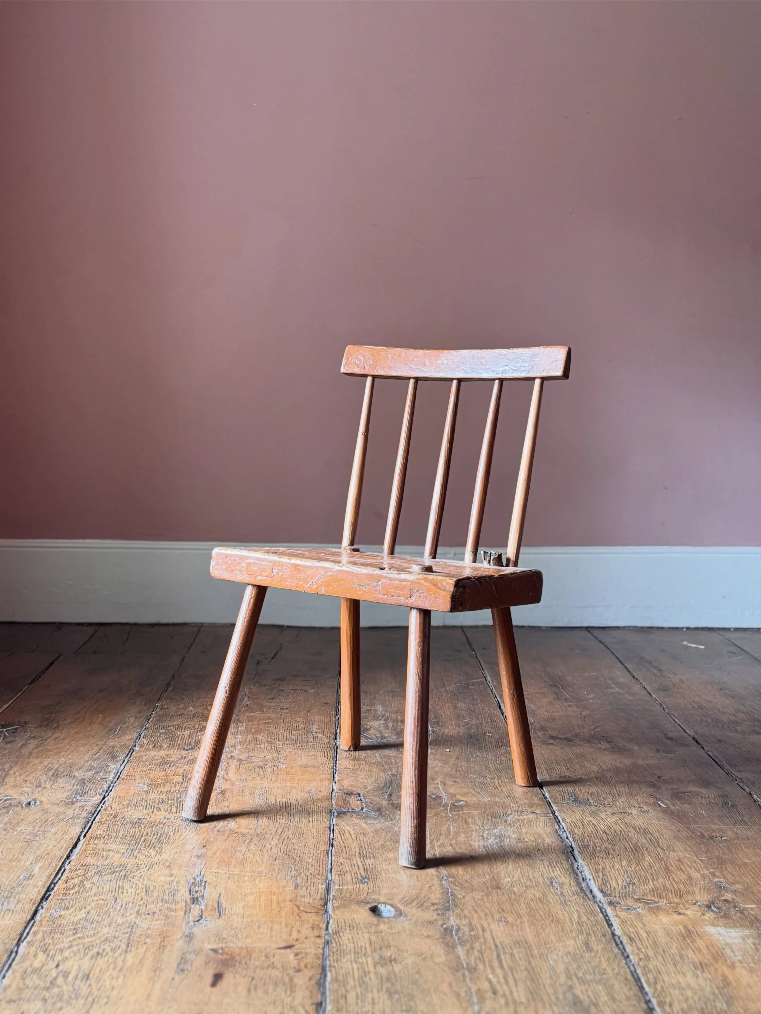This vernacular 19th Century Irish chair from County Antrim has been overpainted many times over its life. The current top layer is a striking orange. A very primitive yet elegant design typical of the Antrim area of Ireland. A lovely chair with lots
