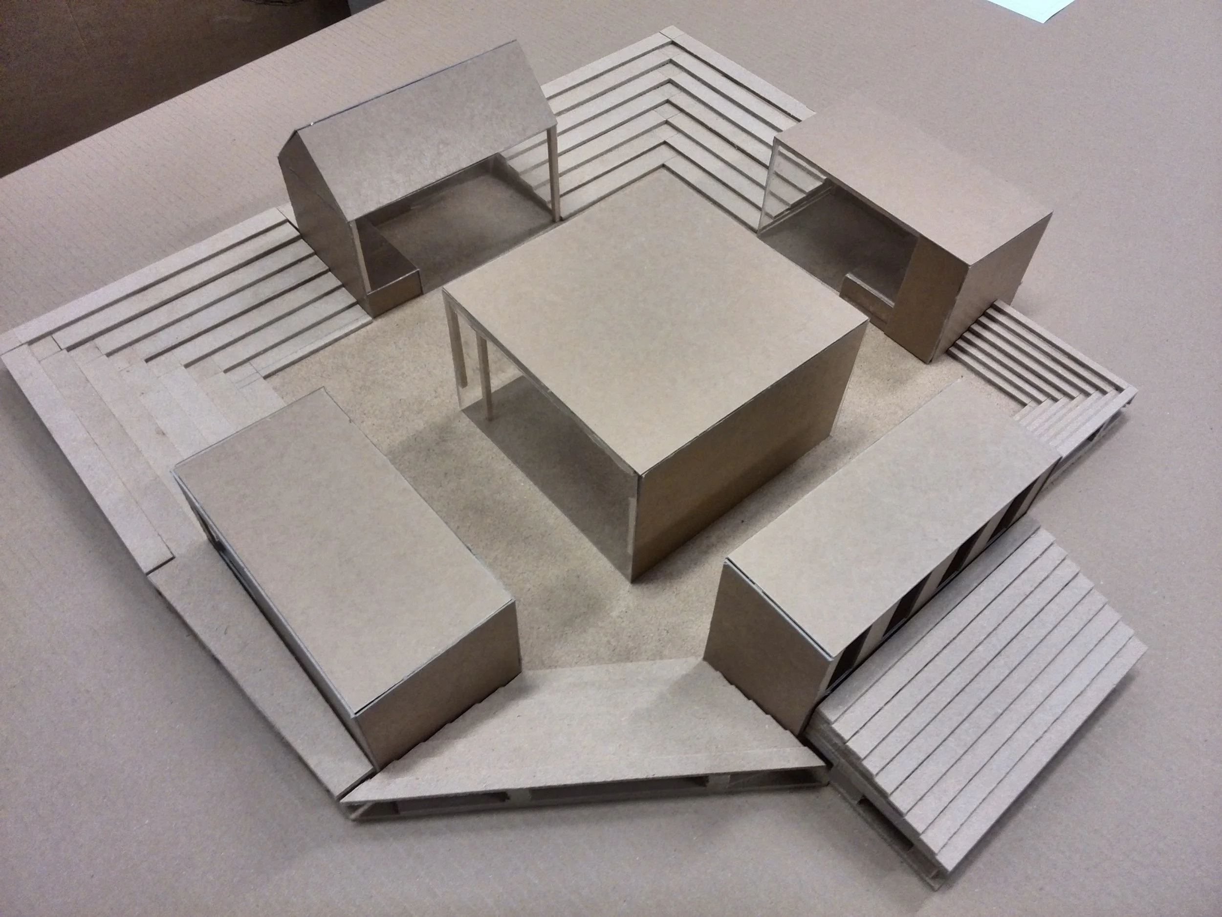 Architectural model of a modern building with multiple rectangular structures and outdoor deck areas.