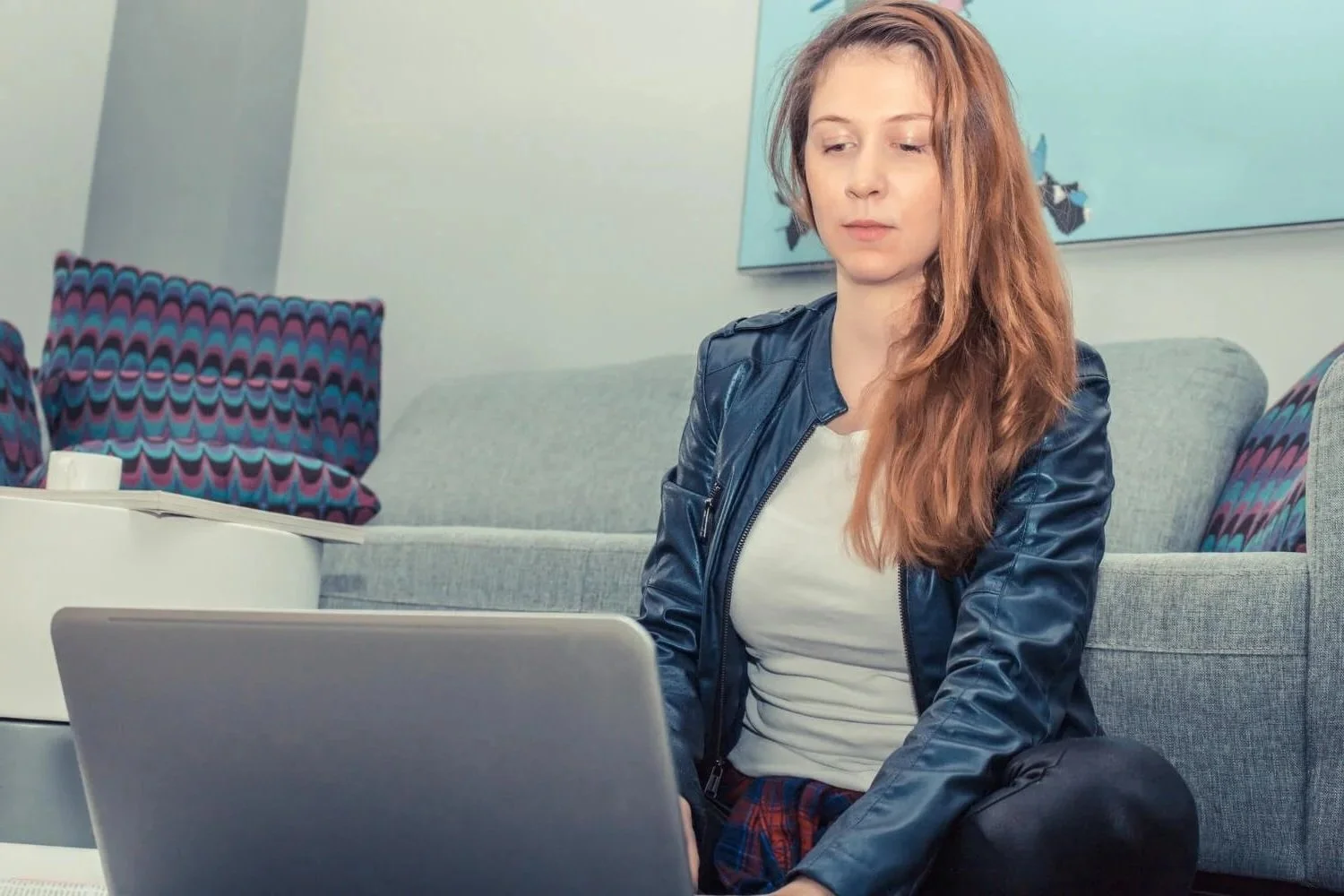 Woman on comfortable couch with laptop during intensive Brainspotting therapy session