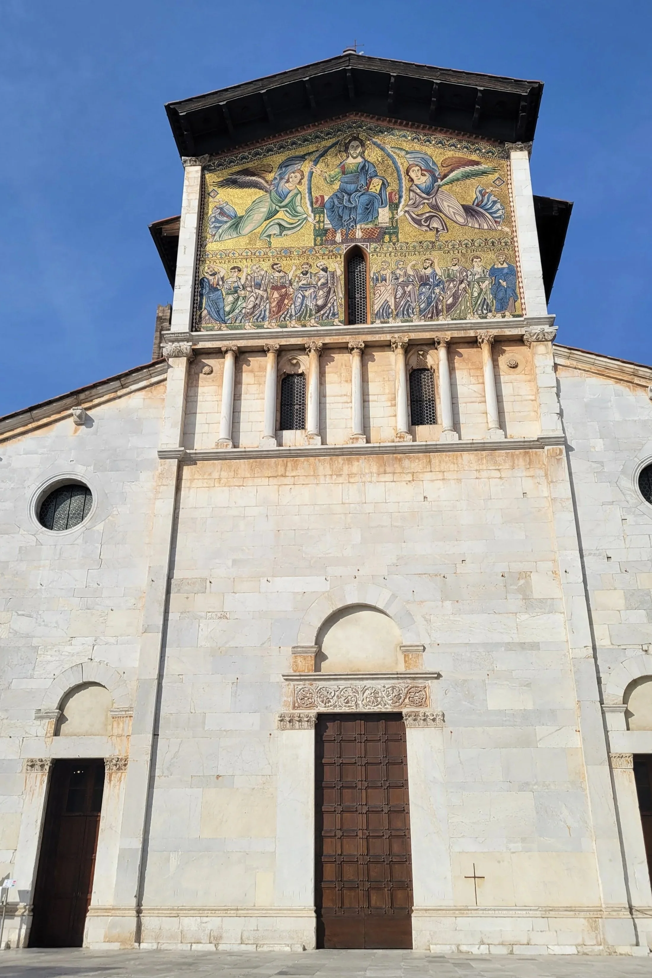 golden mosaic covering the facade of this old church in Lucca, Italy. depicting Jesus and his apostles