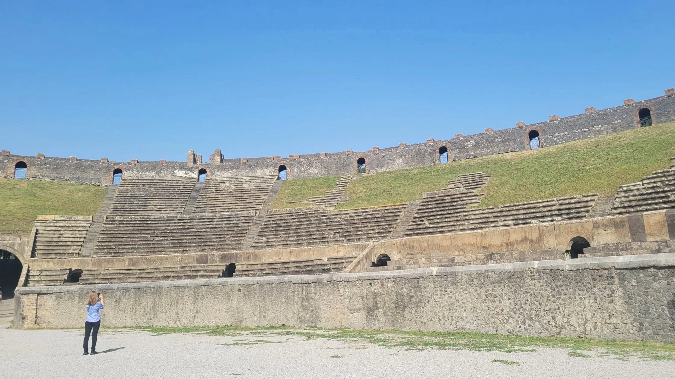 the ancient amphitheatre green patches cover the spots where the benches have been destroyed