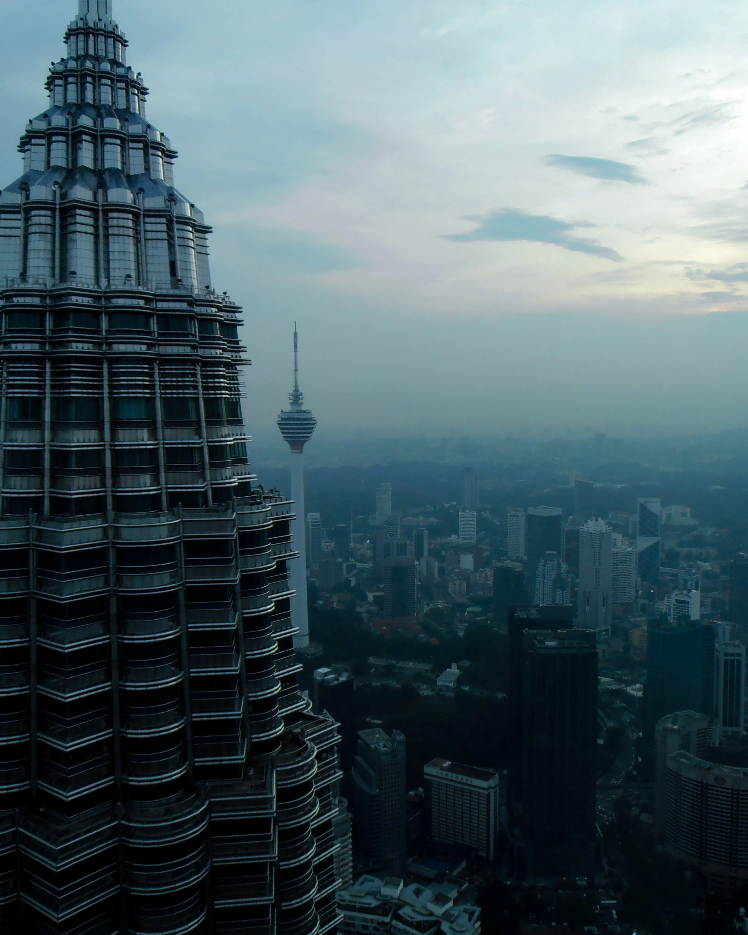 Evening from the viewing deck of the Petronas Tower. The twin tower can be seen on the left side of the image while a fading sunset is on the right.