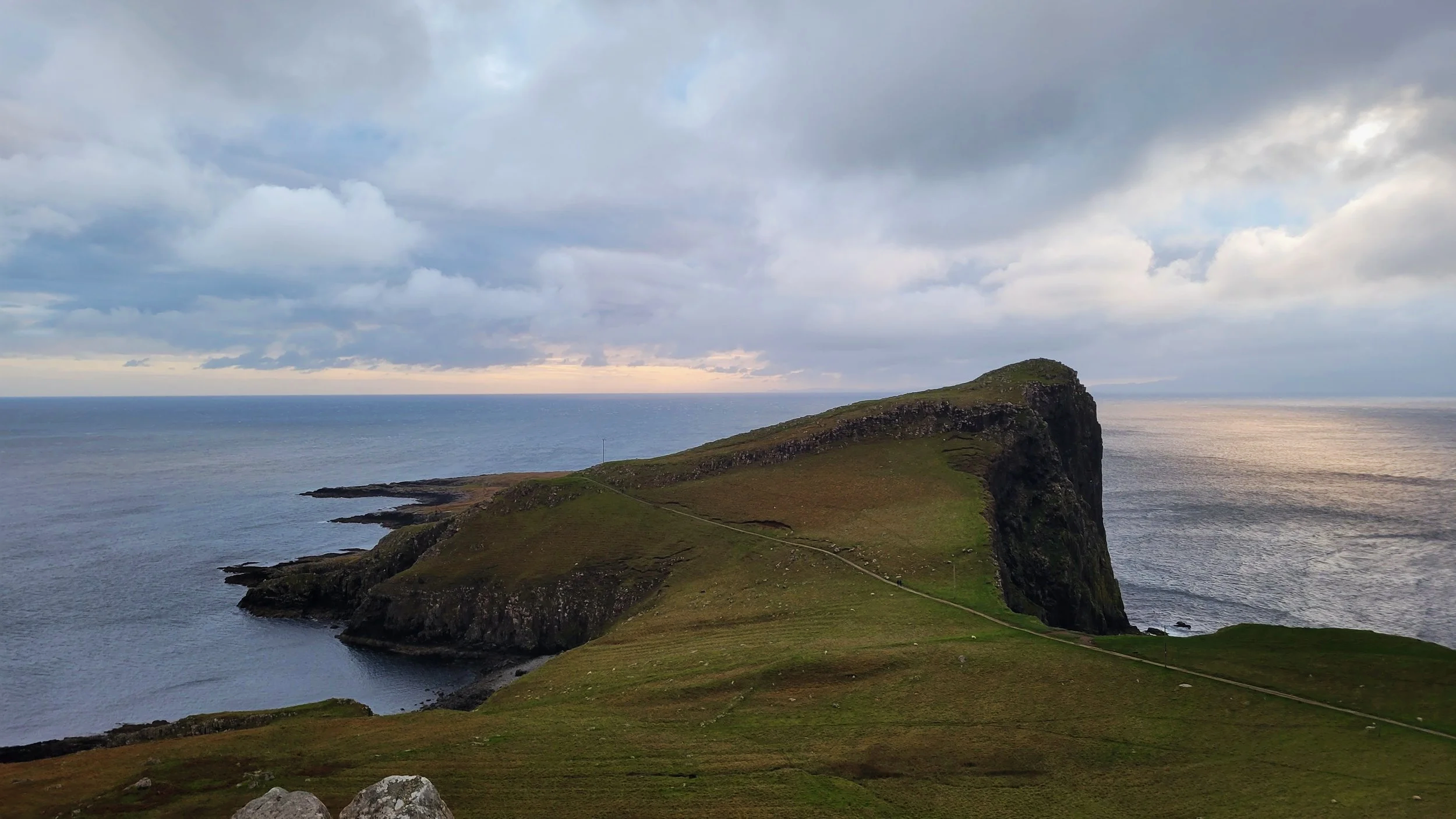 A light pink sunset over the water at Neist Point on isle of skye