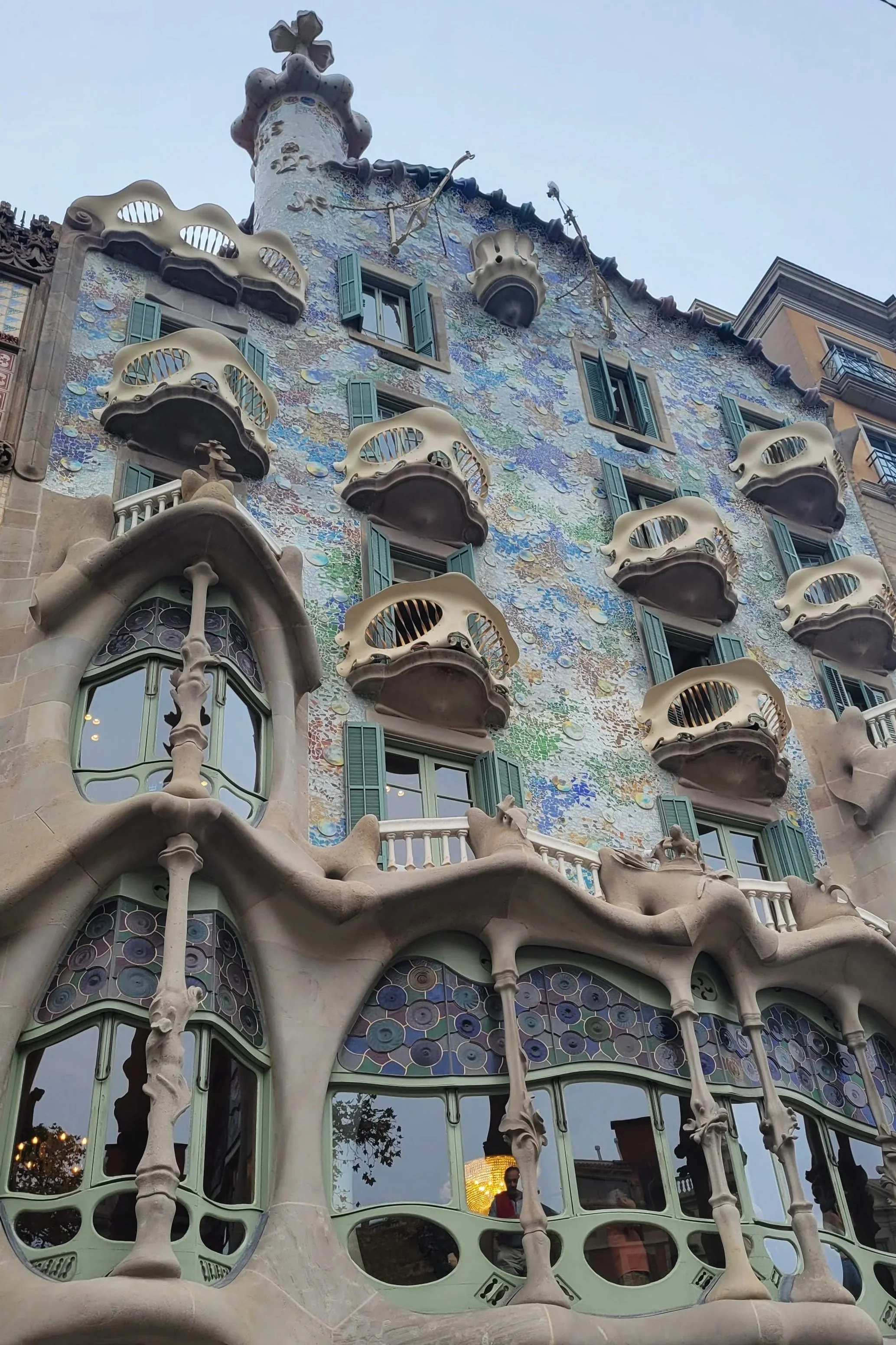 facade covered in cool toned tiles, and off white balconies.