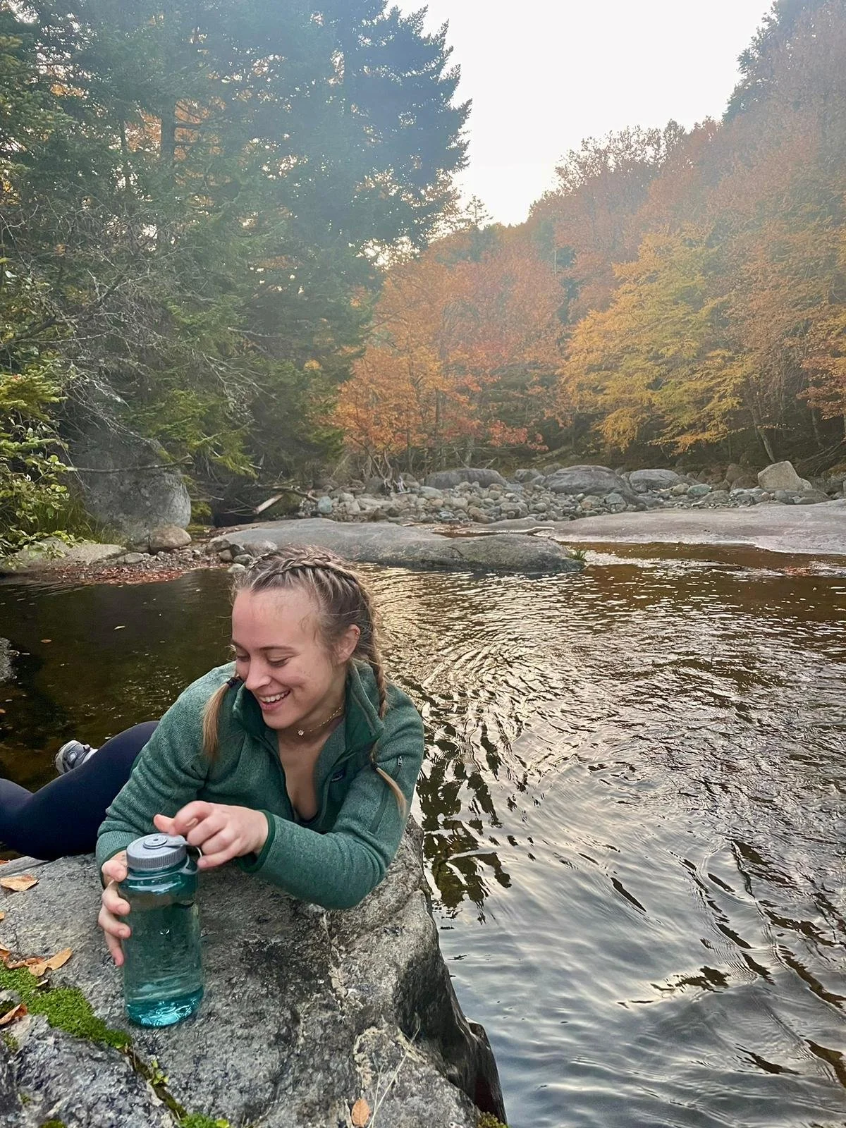 Megan filling her water bottle in stream near Johns brooke lodge