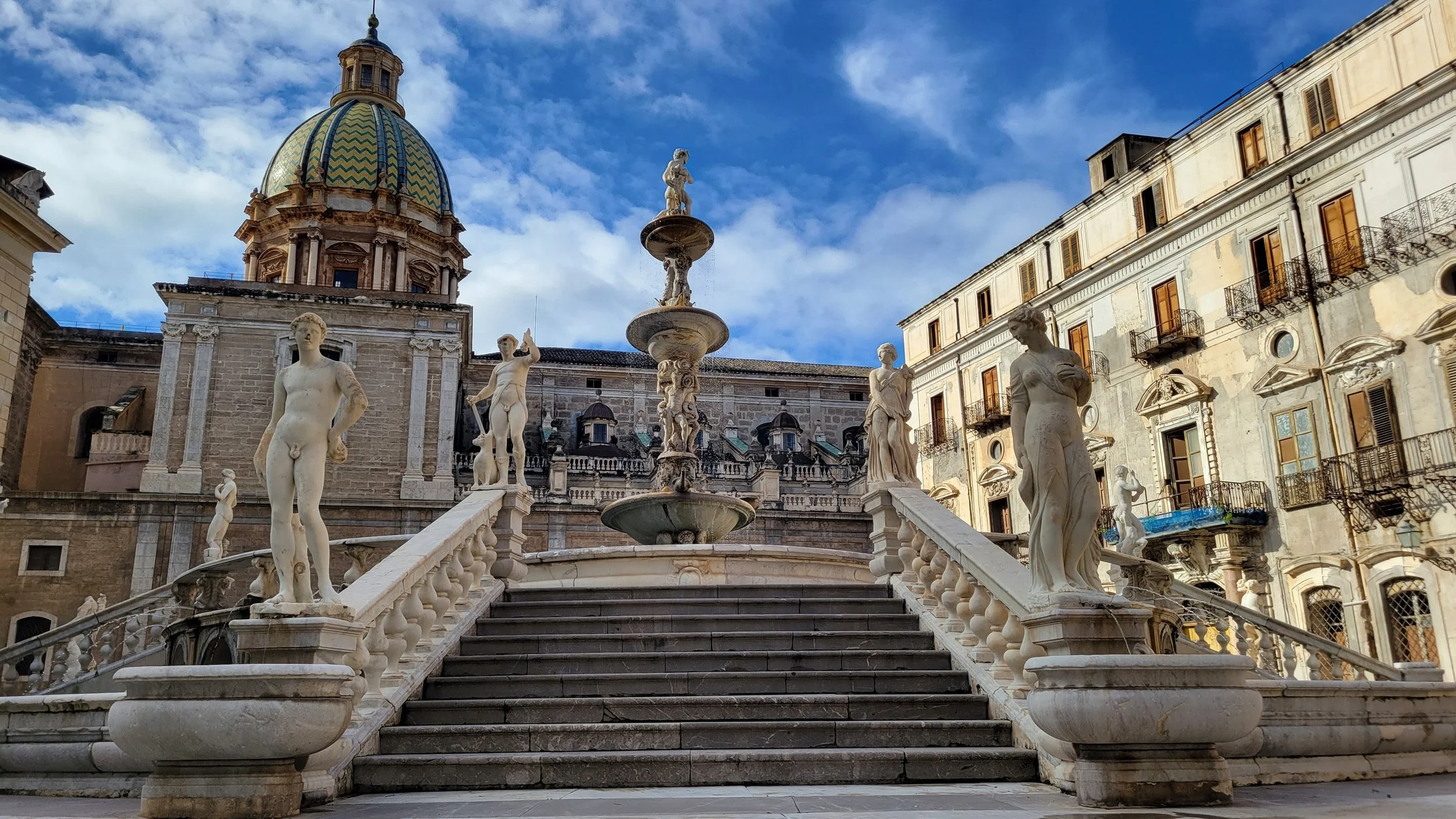 Large marble fountain in front of a duomo